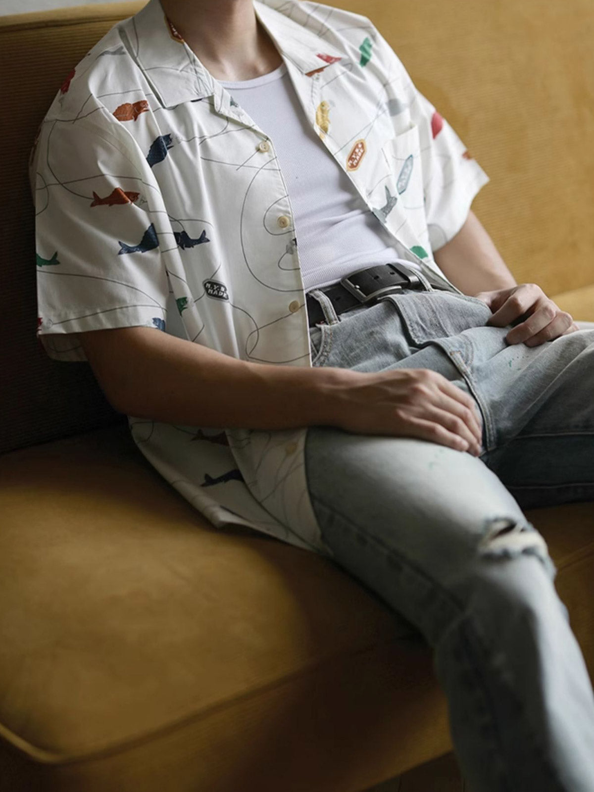 モデルが鯉プリントのハワイアンシャツを着用し、夏のカジュアルスタイルを披露。