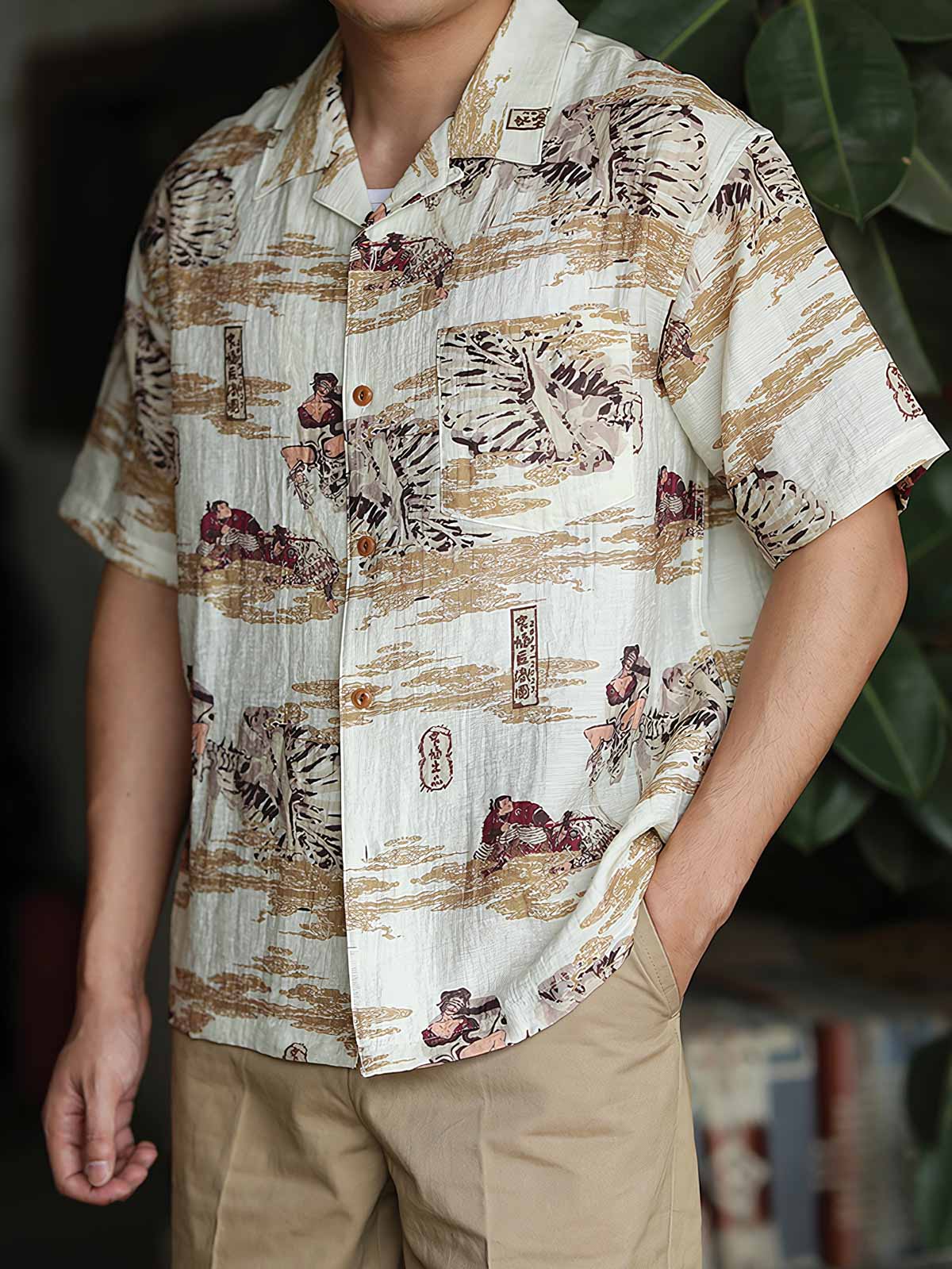 モデルが浮世絵プリントのハワイアンシャツを着用し、カジュアルパンツと組み合わせたスタイリング。