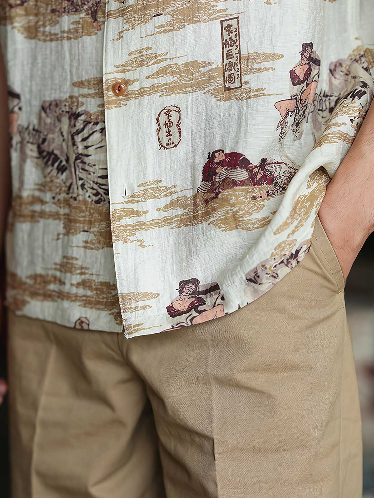 モデルが浮世絵プリントのハワイアンシャツを着用し、カジュアルパンツと組み合わせたスタイリング。