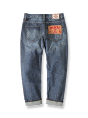 ヴィンテージスプラッシュインク加工とイタリア製植物タンニンレザーラベルを特徴とするヘビーウェイトセルビッジデニムクロップドパンツの背面全景