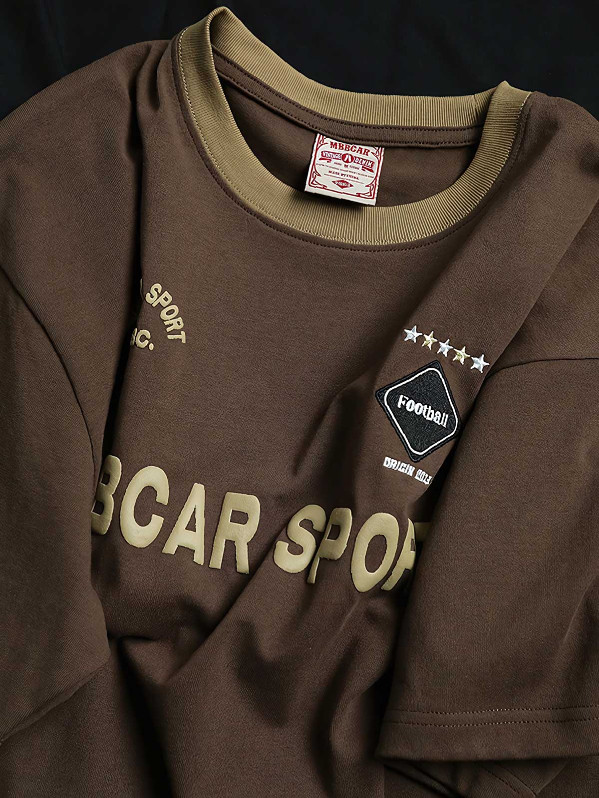 Tシャツの発泡プリントと高密度のサテンステッチ刺繍のクローズアップ