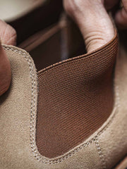 製品画像:
ライトブラウンのスエードチェルシーブーツ全体画像。シンプルで洗練されたデザインが特徴で、秋冬シーズンに最適なスタイルを提案します。
詳細画像:
チェルシーブーツのゴムバンドとスエードの質感がクローズアップされたディテール画像。履きやすさとデザインの美しさが強調されています。