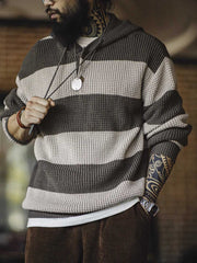 モデルが着用するブルーグリーンのバイカラーストライプフーデッドニット - カジュアルなスタイルを披露