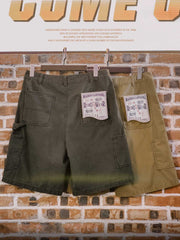 ヴィンテージ加工が施されたログマン・マルチポケットショーツの正面ビュー。純棉素材で作られ、直筒カットとサイドバックのツールポケットが特徴。