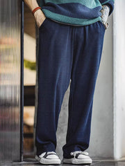 製品画像: ワッフルニットドレープ効果付きカジュアルパンツ正面図
詳細画像: パンツのディテール、白い編み込みドローストリングと石風ビーズ