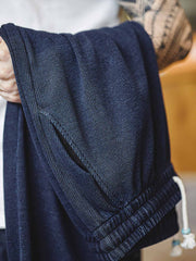 製品画像: ワッフルニットドレープ効果付きカジュアルパンツ正面図
詳細画像: パンツのディテール、白い編み込みドローストリングと石風ビーズ