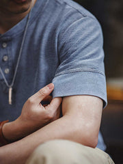 モデルがリラックスフィットのニットデニムヘンリーシャツを着用し、カジュアルなスタイルを披露。