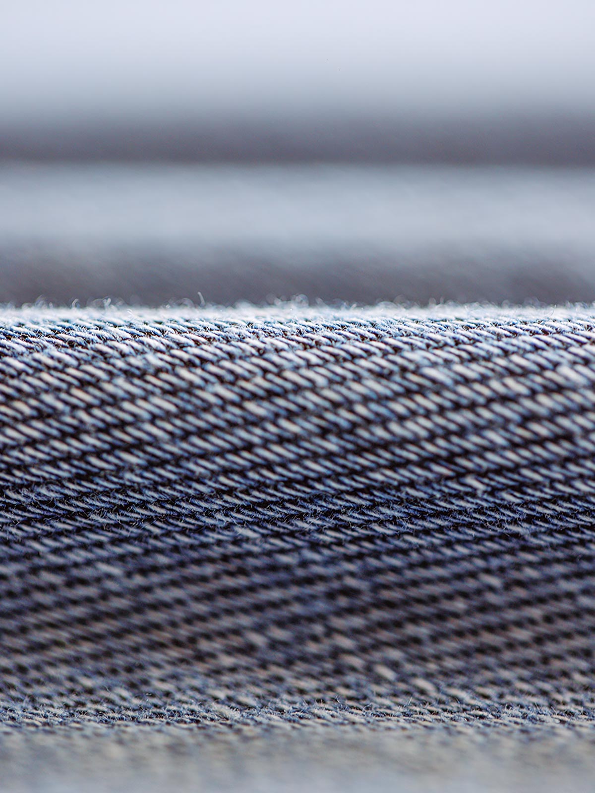 特殊な色落ち効果が施されたニットデニム生地のクローズアップ。