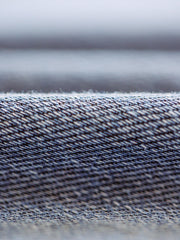 特殊な色落ち効果が施されたニットデニム生地のクローズアップ。