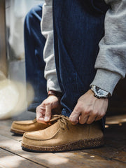 詳細画像: コルク粒入りミッドソールと波形ラバーアウトソールのディテール展示で、快適な履き心地を提供。
モデル画像: スエードレザーカンガルーシューズを淡色ソックスとコーディネートしたスタイリング例。