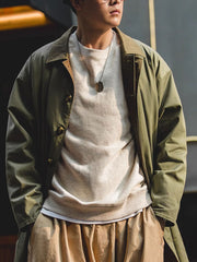 詳細画像: 配色されたカラー(襟)とフライフロント、一文字型斜めポケットのディテール、上品で洗練されたデザイン
モデル画像: モデルが着用したバルマカーン中長丈コートの全身スタイリング、シンプルでモダンな通勤・日常使い