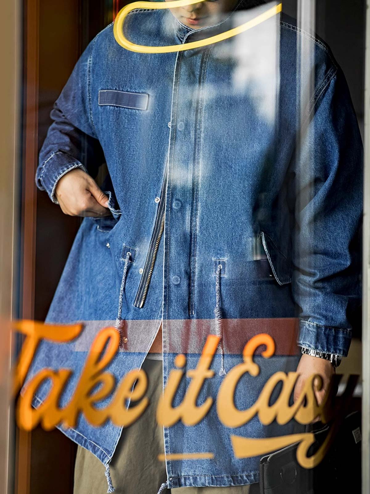 詳細画像: フィッシュテールデザインとウエストドローコードのディテール。調整可能なシルエットで、快適なフィット感を提供
モデル画像: モデルが着用したM65デニムフィッシュテールコートの全身スタイリング。秋のストリートカジュアルに最適なルーズフィットシルエット