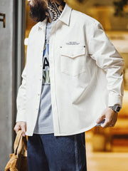 詳細画像:
「ヘリンボーン ワーク オーバーシャツのディテールクローズアップ。胸元に配置されたシングルポケットと黒いリベットをイメージした飾りがアクセントとなり、英字プリントがモダンな要素を加えています。ヘリンボーン生地が視覚的な立体感とヴィンテージ感を演出。」
モデル画像:
「モデルがヘリンボーン ワーク オーバーシャツを着用し、ヴィンテージワークパンツと合わせたクラシックでモダンなスタイルを披露。ルーズフィットのシルエットが快適さを提供し、四季を通じて活躍できる一着。」