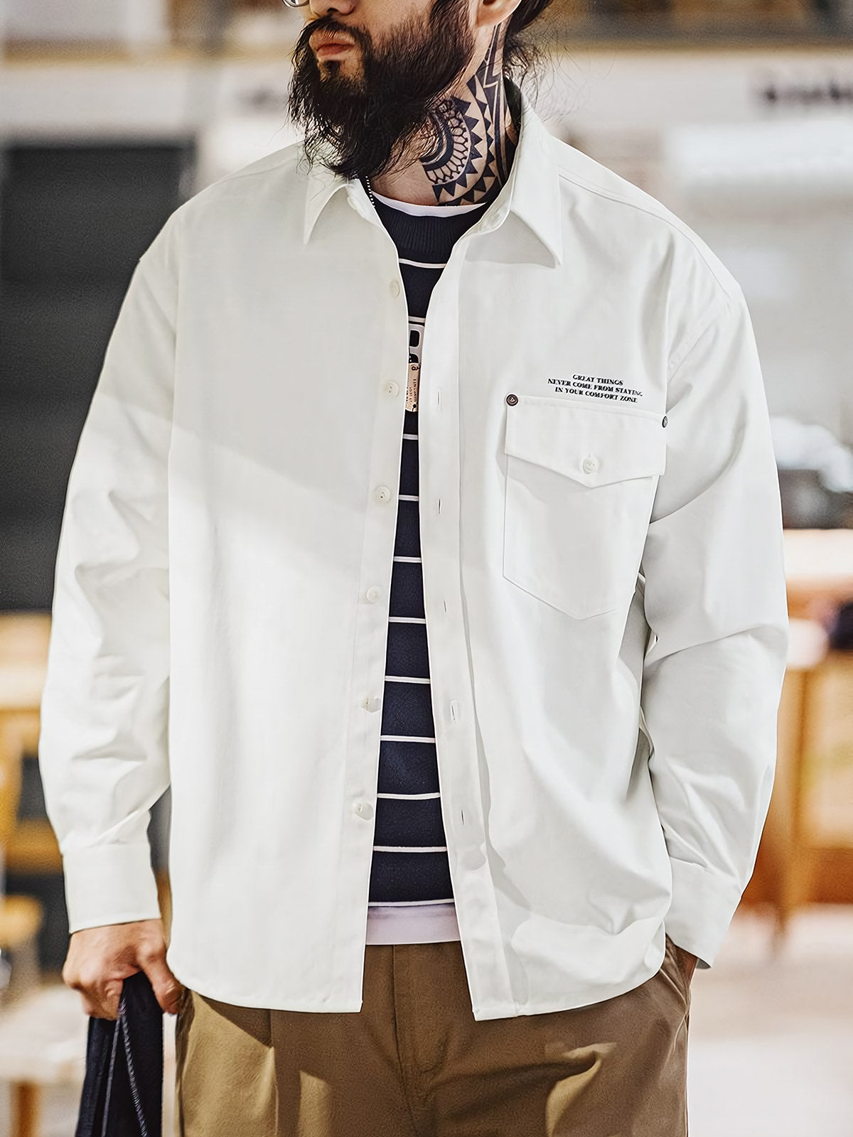 詳細画像:
「ヘリンボーン ワーク オーバーシャツのディテールクローズアップ。胸元に配置されたシングルポケットと黒いリベットをイメージした飾りがアクセントとなり、英字プリントがモダンな要素を加えています。ヘリンボーン生地が視覚的な立体感とヴィンテージ感を演出。」
モデル画像:
「モデルがヘリンボーン ワーク オーバーシャツを着用し、ヴィンテージワークパンツと合わせたクラシックでモダンなスタイルを披露。ルーズフィットのシルエットが快適さを提供し、四季を通じて活躍できる一着。」