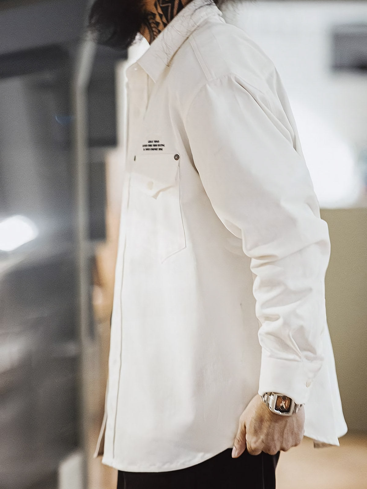 詳細画像:
「ヘリンボーン ワーク オーバーシャツのディテールクローズアップ。胸元に配置されたシングルポケットと黒いリベットをイメージした飾りがアクセントとなり、英字プリントがモダンな要素を加えています。ヘリンボーン生地が視覚的な立体感とヴィンテージ感を演出。」
モデル画像:
「モデルがヘリンボーン ワーク オーバーシャツを着用し、ヴィンテージワークパンツと合わせたクラシックでモダンなスタイルを披露。ルーズフィットのシルエットが快適さを提供し、四季を通じて活躍できる一着。」