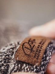 製品画像:ヴィンテージ風ツートーンニットビーニーの全体展示。グレーとブラウンの糸が織り交ぜられたシンプルで洗練されたデザインが特徴。
詳細画像:縁部分のディテールと編み糸のテクスチャーをクローズアップ。柔らかい素材で寒い季節にも快適。