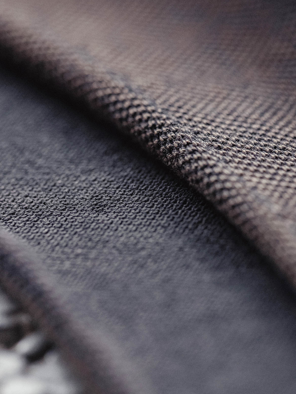 詳細画像:ネックラインの逆三角形と裾のリブ仕上げのディテール