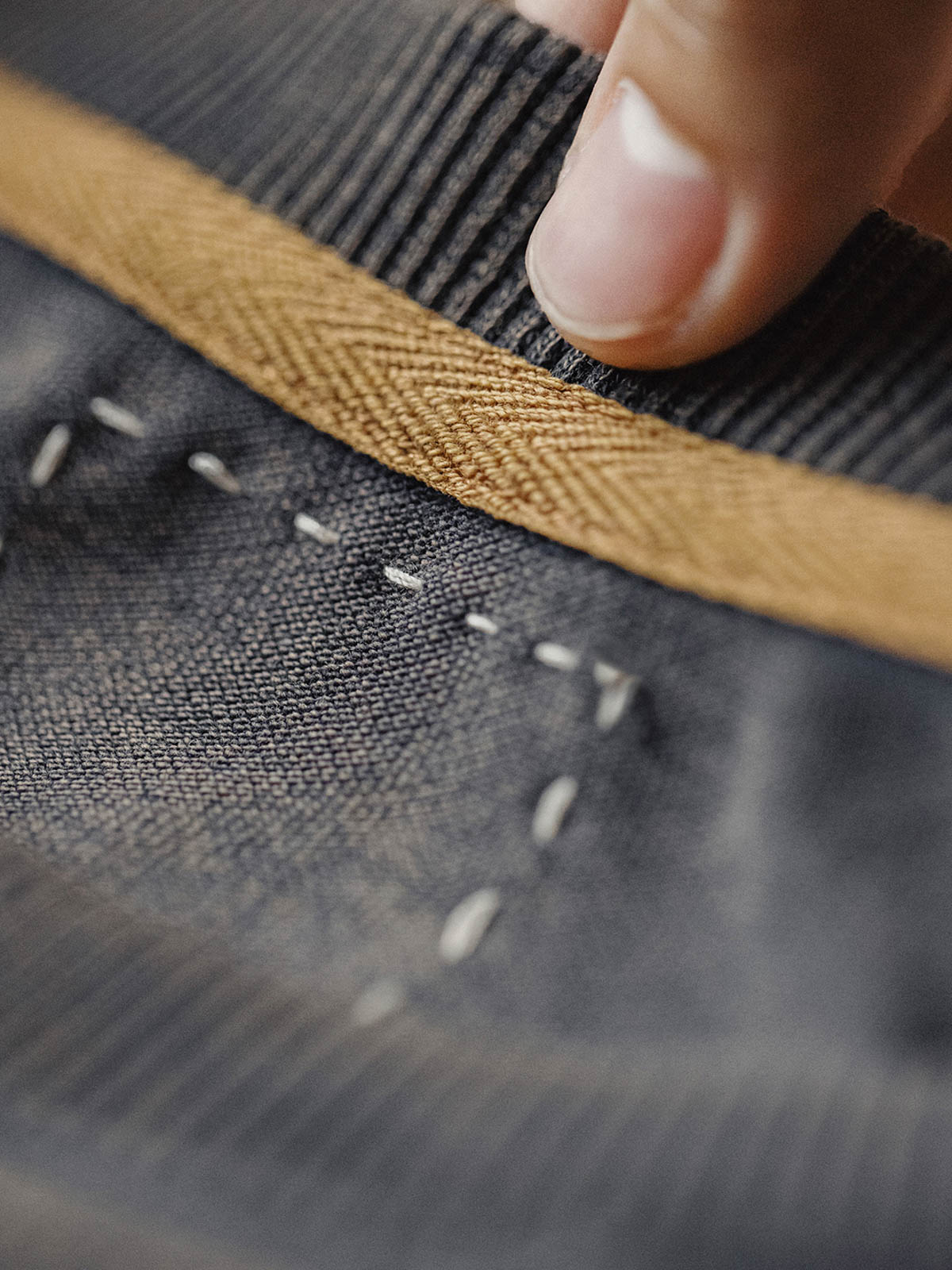 詳細画像:ネックラインの逆三角形と裾のリブ仕上げのディテール