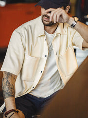 モデルがノンアイロン竹節平織オーバーサイズ半袖シャツを着用し、カジュアルパンツとシンプルなスニーカーでコーディネート。リラックスした夏のスタイルを演出し、アクセサリーでスタイリッシュなアクセントを加えています。