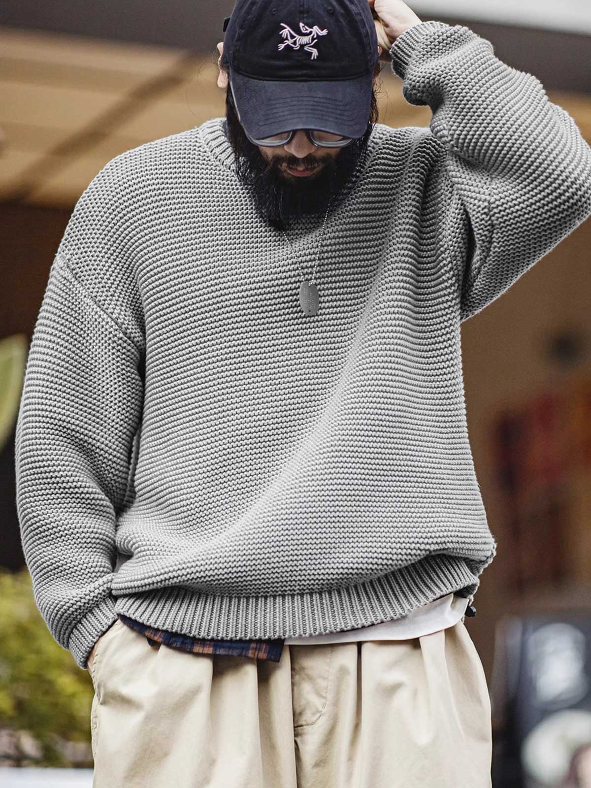 詳細画像: ニットの編み目が立体的に見えるディテール画像。粗い糸で編まれた質感が、ヴィンテージ調の雰囲気を引き出し、耐久性の高さと毛玉の付きにくさを表現。
モデル画像: モデルがヴィンテージ風の重厚な厚手テクスチャーニットセーターを着用している様子。スマイルカーブネックのデザインが映え、ゆったりとしたドロップショルダーで、冬のレイヤードコーディネートにも最適なシルエット。