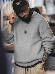 詳細画像: ニットの編み目が立体的に見えるディテール画像。粗い糸で編まれた質感が、ヴィンテージ調の雰囲気を引き出し、耐久性の高さと毛玉の付きにくさを表現。
モデル画像: モデルがヴィンテージ風の重厚な厚手テクスチャーニットセーターを着用している様子。スマイルカーブネックのデザインが映え、ゆったりとしたドロップショルダーで、冬のレイヤードコーディネートにも最適なシルエット。