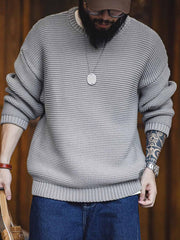 詳細画像: ニットの編み目が立体的に見えるディテール画像。粗い糸で編まれた質感が、ヴィンテージ調の雰囲気を引き出し、耐久性の高さと毛玉の付きにくさを表現。
モデル画像: モデルがヴィンテージ風の重厚な厚手テクスチャーニットセーターを着用している様子。スマイルカーブネックのデザインが映え、ゆったりとしたドロップショルダーで、冬のレイヤードコーディネートにも最適なシルエット。