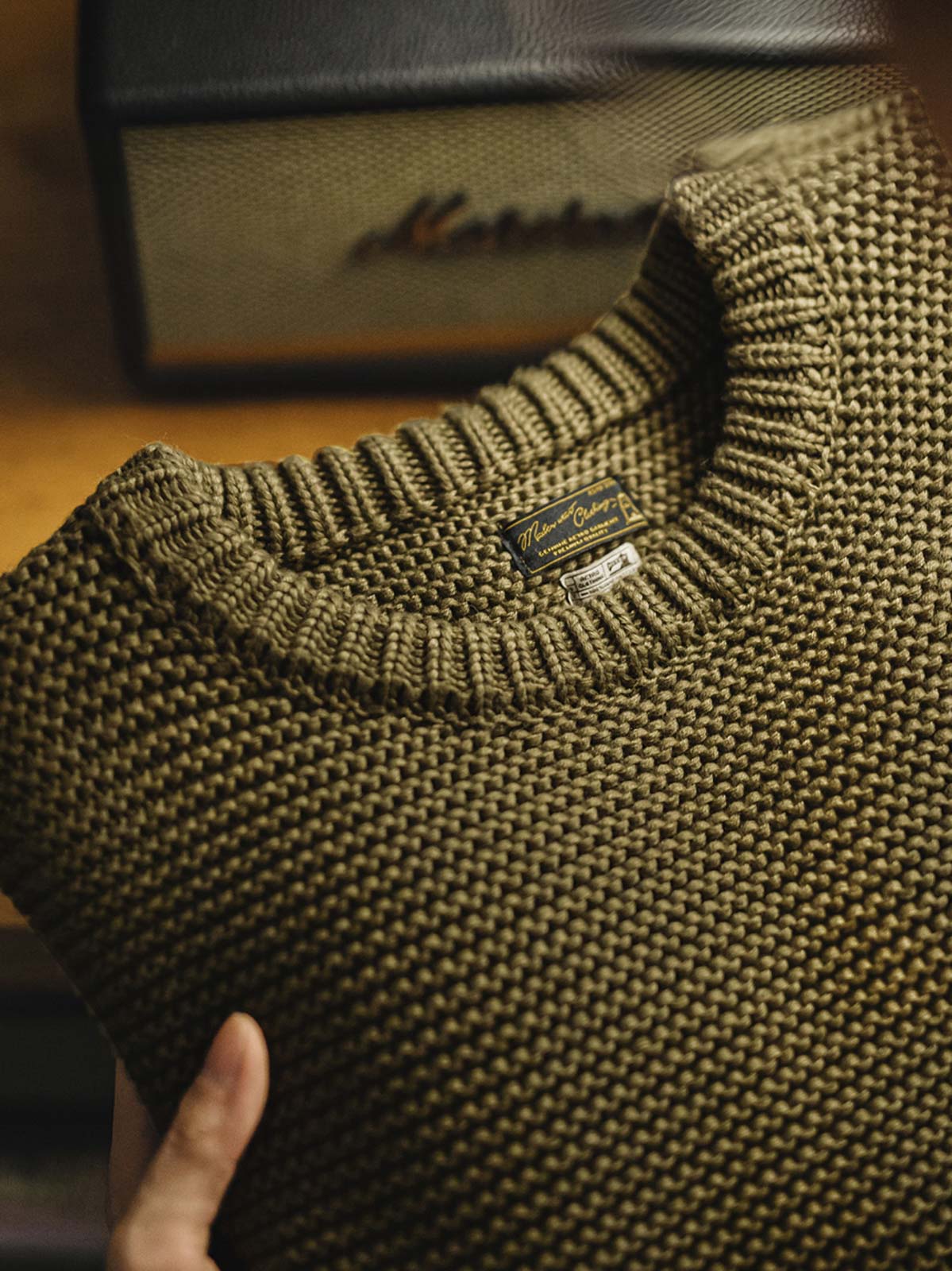 製品画像: ヴィンテージ風の重厚な厚手テクスチャーニットセーター全体像。1000g以上の重量感で、立体的な編み目が施され、冬に適した温かみと存在感が際立つデザイン。
詳細画像: ニットの編み目が立体的に見えるディテール画像。粗い糸で編まれた質感が、ヴィンテージ調の雰囲気を引き出し、耐久性の高さと毛玉の付きにくさを表現。