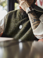 製品画像: アメカジレトロ風モスグリーンVネックニットベストのフロントビュー。柔らかいウール混素材で、秋冬の重ね着風スタイルに最適
詳細画像: 爪型木製ボタンとリブデザインのディテール。レトロなアクセントが魅力のVネックニットベスト