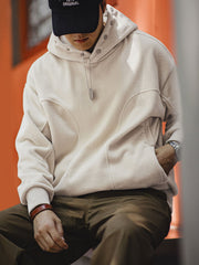 詳細画像: パーカーの8つのボタン付きフードとマット質感スナップボタンのディテール
モデル画像: ダブルフリース フード付きプルオーバーパーカーを着たモデル、リラックスした日常カジュアルスタイルを披露