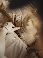 製品画像: レトロ風テーラード襟厚手中綿ジャケットのフロントビュー。防風・防寒機能付きの秋冬用アウター
詳細画像: ブロンズカラーのジッパーとテーラード襟のディテール。スタンドカラーとリフレクター付きロゴで機能性を強化