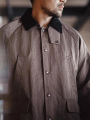 詳細画像:イギリスチェックの裏地と黒のコーデュロイラペルのディテール展示。クラシックなアクセントがコート全体に深いインプレッションをもたらす。
モデル画像:モデルがオーバーサイズのレトロハンティング風コートを着用し、袖口を巻き上げたスタイル。ブーツと合わせてアメリカンワークテイストを演出。