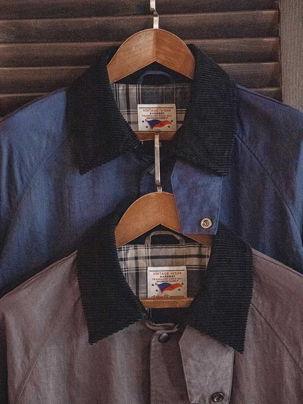 製品画像:アメリカンレトロスタイルのゆったりとしたハンティング風コートの正面展示図。80年代のハンティング要素を取り入れ、現代のファッションに合わせたオーバーサイズデザインが特徴。
詳細画像:イギリスチェックの裏地と黒のコーデュロイラペルのディテール展示。クラシックなアクセントがコート全体に深いインプレッションをもたらす。