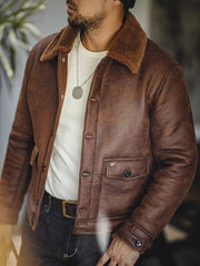 詳細画像:七つボタンの前立てと厚手のシープスキン襟のディテールをクローズアップ。ヴィンテージ感と実用性を兼ね備えた仕様。
モデル画像:モデルがムートンボマージャケットを着用し、デニムパンツとワークブーツを合わせたハードなバイカースタイルを提案。