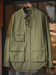 製品画像
ノマドジャーナリストシャツの正面デザイン。1954年ベトナム戦争時のAP通信戦地カメラマンの装備を再現したミリタリーギア風デザインで、3つのフラップ付きポケットと軽量梭織(しょうしょく)生地が特徴的
詳細画像
マットな5本爪スナップボタンと、戦地カメラマンの実用性を考慮して配置された3つのフラップ付きポケットのディテール特写。独自のシワ加工が施され、経年変化を楽しめる仕上がり