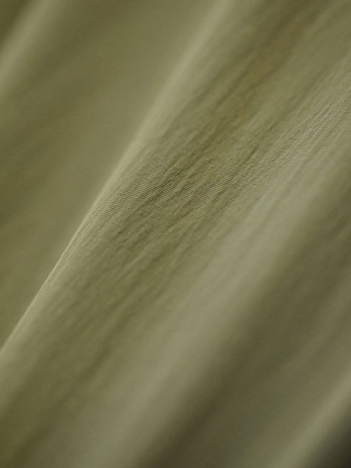 製品画像
ノマドジャーナリストシャツの正面デザイン。1954年ベトナム戦争時のAP通信戦地カメラマンの装備を再現したミリタリーギア風デザインで、3つのフラップ付きポケットと軽量梭織(しょうしょく)生地が特徴的
詳細画像
マットな5本爪スナップボタンと、戦地カメラマンの実用性を考慮して配置された3つのフラップ付きポケットのディテール特写。独自のシワ加工が施され、経年変化を楽しめる仕上がり