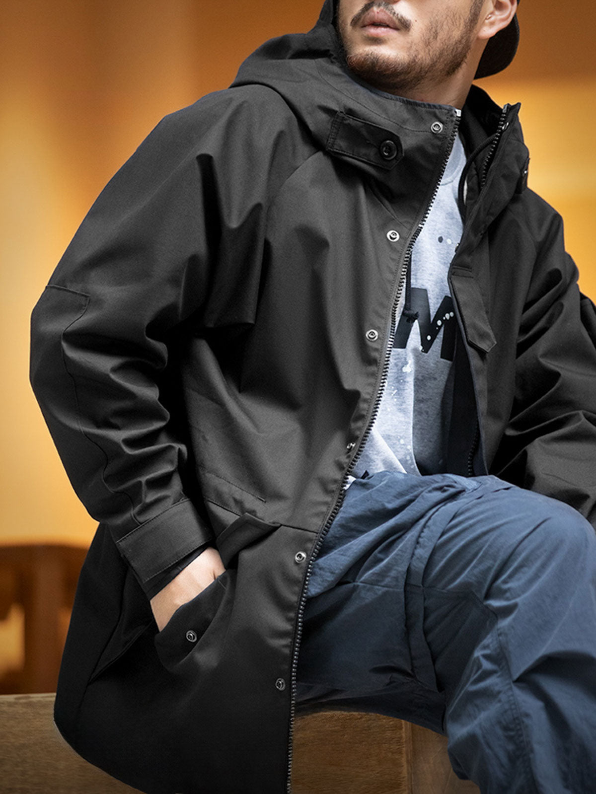 詳細画像: ドローコード付きのフードと左側の機能ポケット、スナップボタンが付いた斜めポケットのディテール。ダブルジップ仕様で実用性を強化
モデル画像: モデルが着用した機能性ナイロンコートの全身スタイリング。秋のデイリースタイルに合わせたルーズフィットで、アウトドアや通勤に適したコート