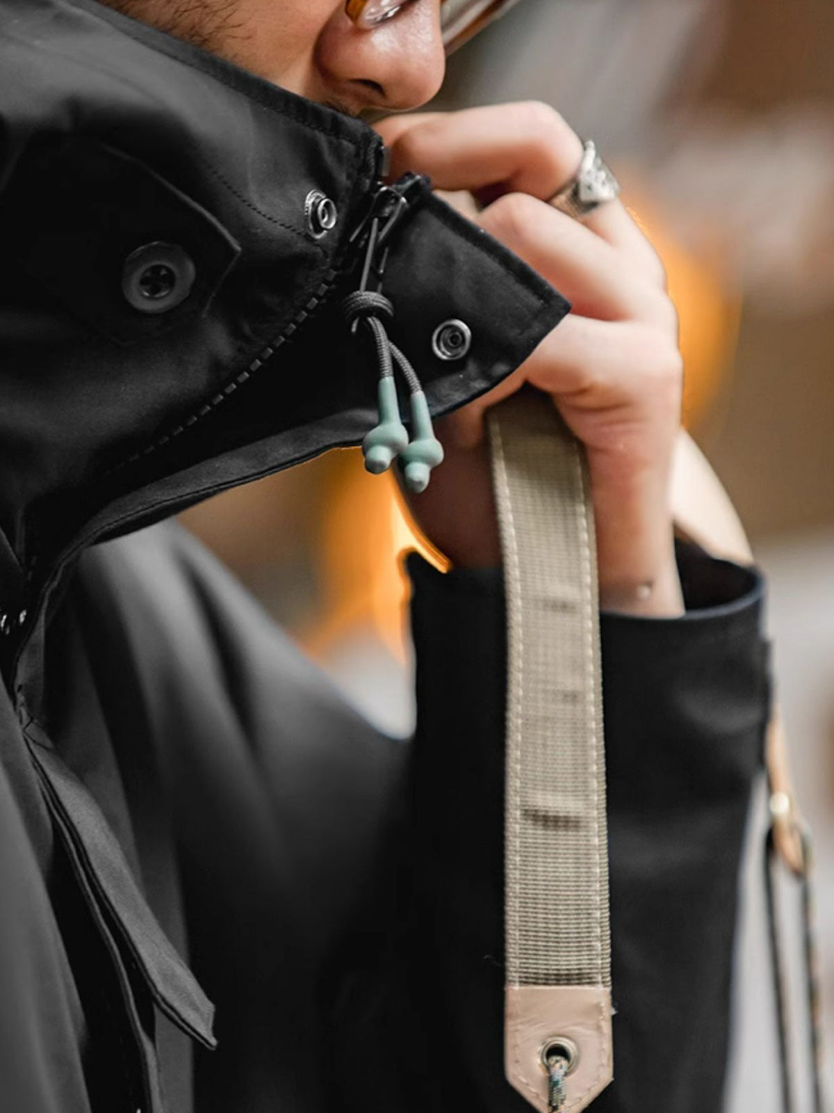 詳細画像: ドローコード付きのフードと左側の機能ポケット、スナップボタンが付いた斜めポケットのディテール。ダブルジップ仕様で実用性を強化
モデル画像: モデルが着用した機能性ナイロンコートの全身スタイリング。秋のデイリースタイルに合わせたルーズフィットで、アウトドアや通勤に適したコート