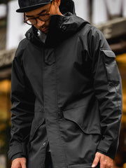 詳細画像: ドローコード付きのフードと左側の機能ポケット、スナップボタンが付いた斜めポケットのディテール。ダブルジップ仕様で実用性を強化
モデル画像: モデルが着用した機能性ナイロンコートの全身スタイリング。秋のデイリースタイルに合わせたルーズフィットで、アウトドアや通勤に適したコート