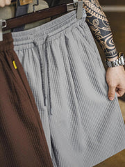 詳細画像:立体チェックのテクスチャーと三重のゴムウエストバンド、ドローコードのディテール