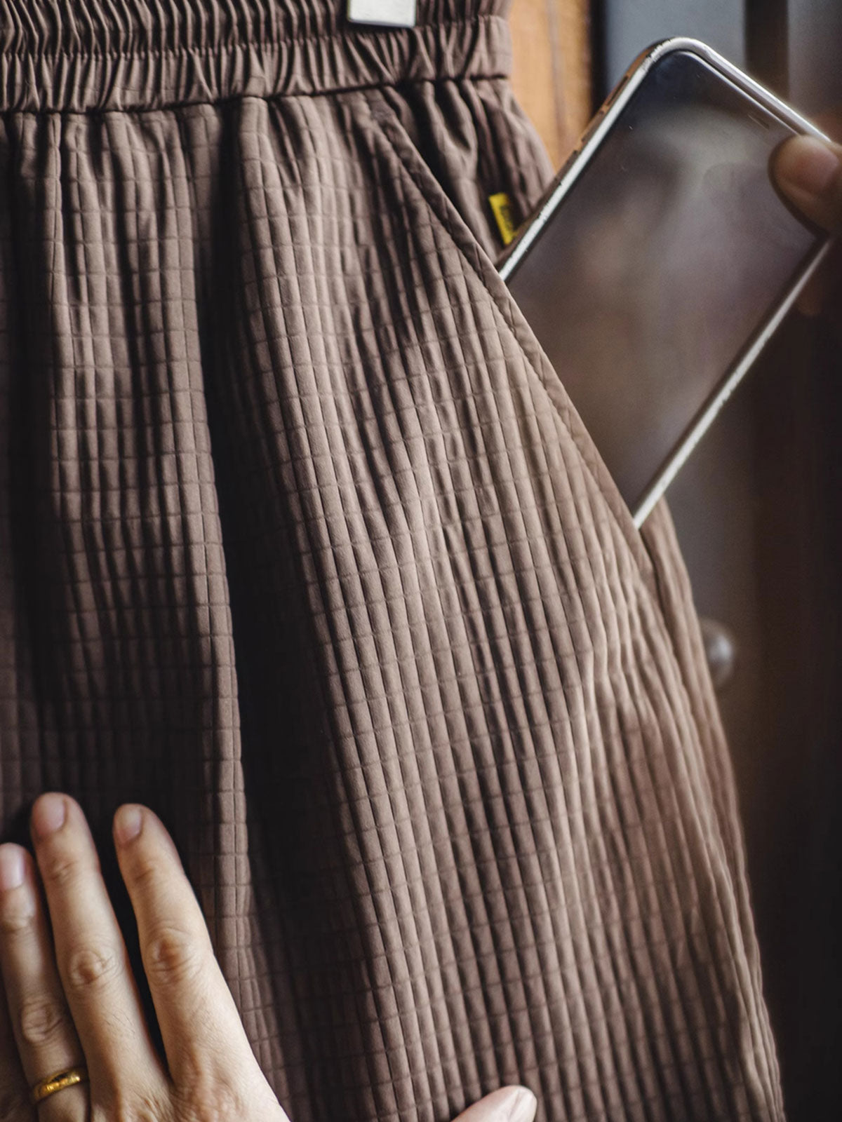 詳細画像:立体チェックのテクスチャーと三重のゴムウエストバンド、ドローコードのディテール