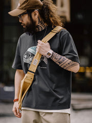 モデルがグレーの深海魚フロックプリントコットンTシャツを着用し、カジュアルパンツとスニーカーでスタイリング。リラックスフィットが週末のリラックススタイルを提案します。
