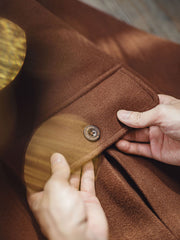 製品画像:学院風のヴィンテージ感漂う牛角ボタン付きフードダッフルコートの正面展示。膝上丈のクラシックデザイン。
詳細画像:木製の牛角ボタンとアコーディオンポケットのディテールをクローズアップ。クラシックなディテールが、全体の完成度を高めています。