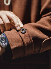 詳細画像:木製の牛角ボタンとアコーディオンポケットのディテールをクローズアップ。クラシックなディテールが、全体の完成度を高めています。
モデル画像:モデルがダッフルコートを着用し、学院風スタイルのカジュアルな冬のコーディネートを提案。