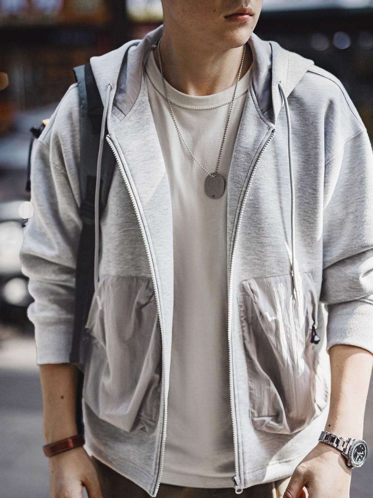 詳細画像
カラーブロックデザインの大容量ポケットと、リブ袖口のディテールをクローズアップした画像。実用性とファッション性を兼ね備えたデザインが際立つ。
モデル画像
モデルがカラーブロック ポケット付き パーカーを着用し、リラックス感のあるカジュアルスタイルを披露した全身画像。外出やスポーツに最適なコーディネート例。