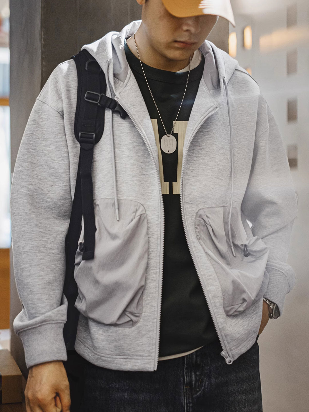 詳細画像
カラーブロックデザインの大容量ポケットと、リブ袖口のディテールをクローズアップした画像。実用性とファッション性を兼ね備えたデザインが際立つ。
モデル画像
モデルがカラーブロック ポケット付き パーカーを着用し、リラックス感のあるカジュアルスタイルを披露した全身画像。外出やスポーツに最適なコーディネート例。