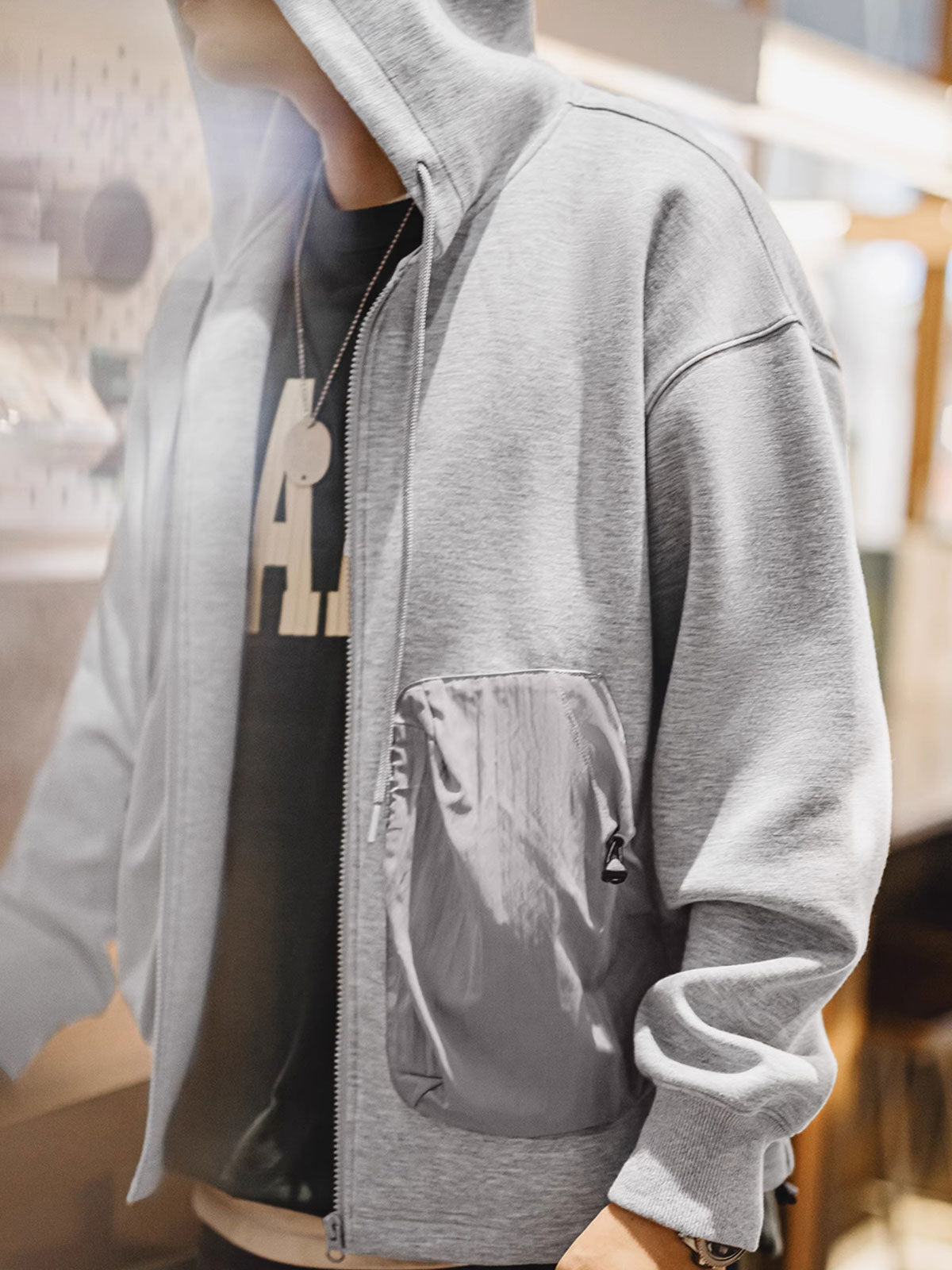 詳細画像
カラーブロックデザインの大容量ポケットと、リブ袖口のディテールをクローズアップした画像。実用性とファッション性を兼ね備えたデザインが際立つ。
モデル画像
モデルがカラーブロック ポケット付き パーカーを着用し、リラックス感のあるカジュアルスタイルを披露した全身画像。外出やスポーツに最適なコーディネート例。