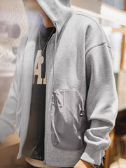 詳細画像
カラーブロックデザインの大容量ポケットと、リブ袖口のディテールをクローズアップした画像。実用性とファッション性を兼ね備えたデザインが際立つ。
モデル画像
モデルがカラーブロック ポケット付き パーカーを着用し、リラックス感のあるカジュアルスタイルを披露した全身画像。外出やスポーツに最適なコーディネート例。