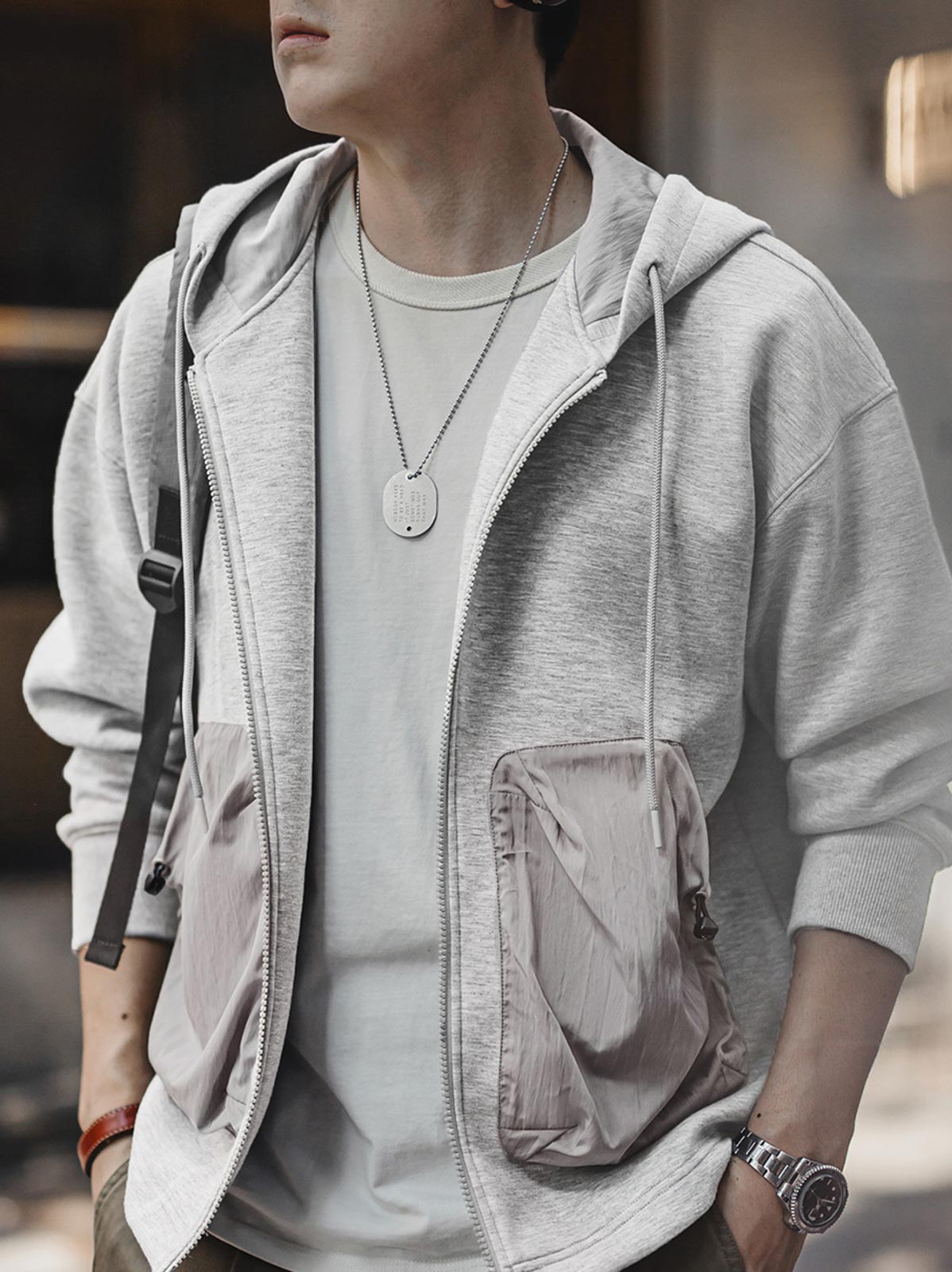 詳細画像
カラーブロックデザインの大容量ポケットと、リブ袖口のディテールをクローズアップした画像。実用性とファッション性を兼ね備えたデザインが際立つ。
モデル画像
モデルがカラーブロック ポケット付き パーカーを着用し、リラックス感のあるカジュアルスタイルを披露した全身画像。外出やスポーツに最適なコーディネート例。