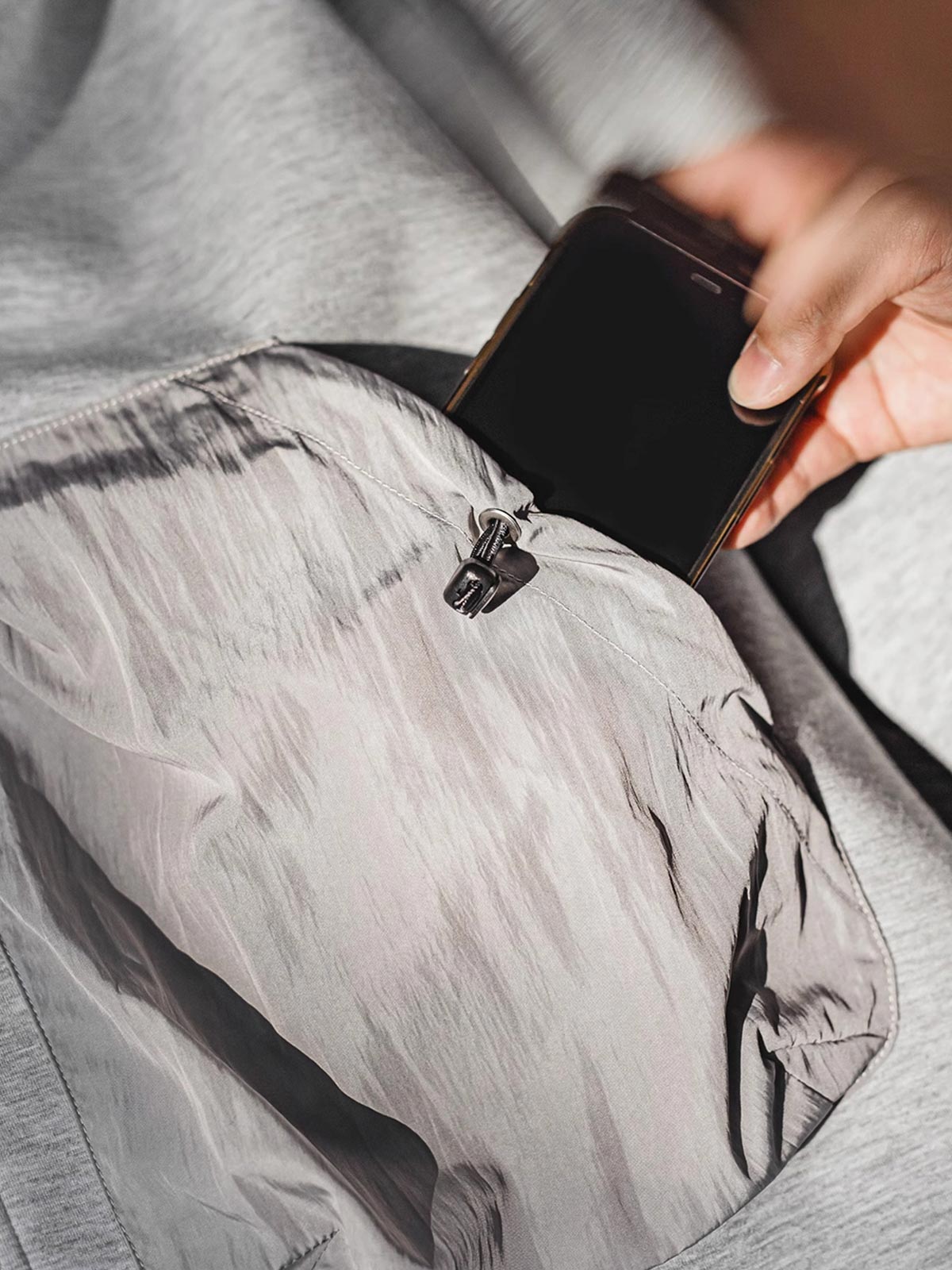 製品画像
軽量で保温性のあるエアレイヤー素材を使用した、カラーブロックデザインのポケット付きパーカーの正面全体画像。スポーツやカジュアルシーンに適した万能な一着。
詳細画像
カラーブロックデザインの大容量ポケットと、リブ袖口のディテールをクローズアップした画像。実用性とファッション性を兼ね備えたデザインが際立つ。