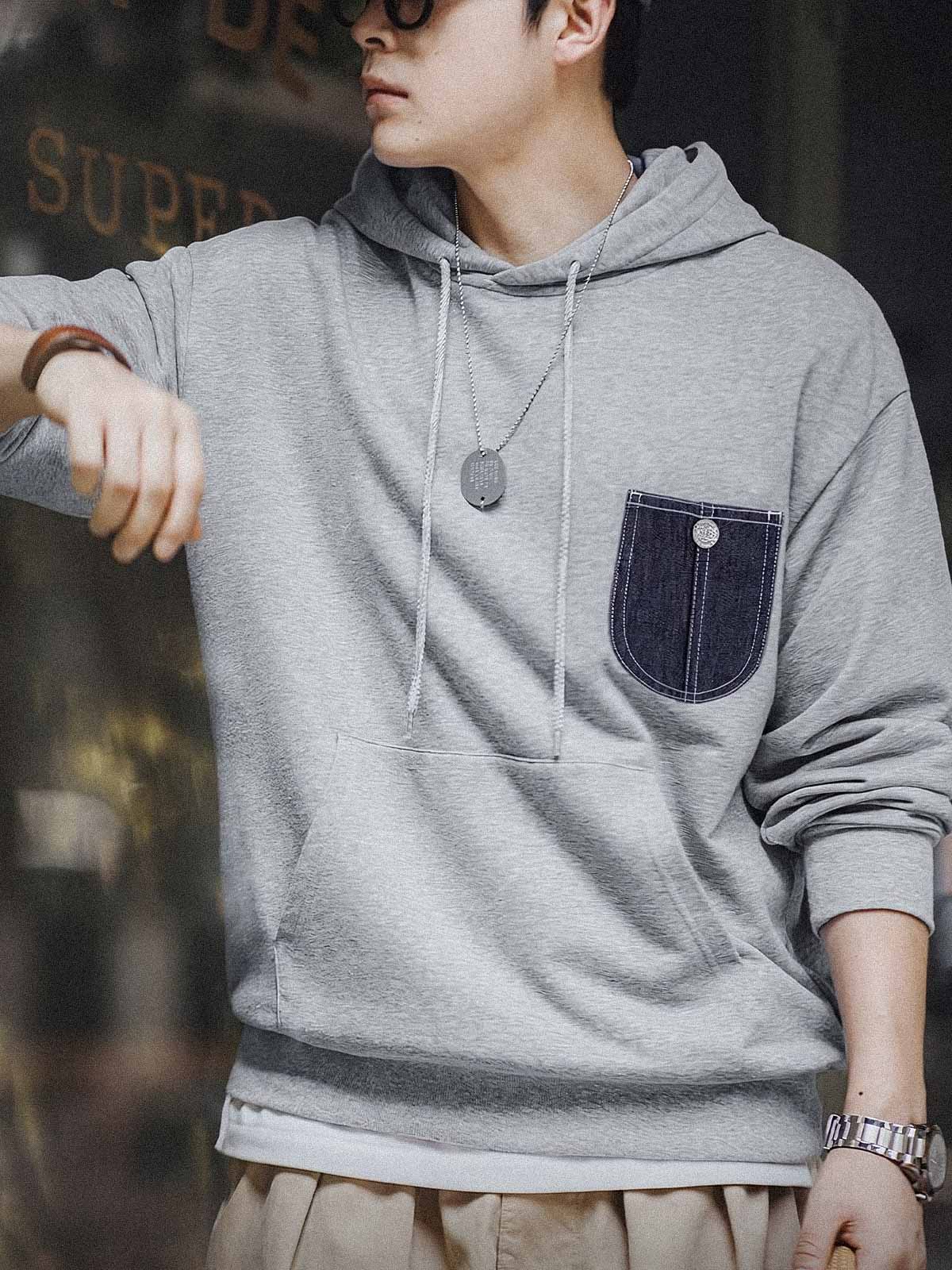 詳細画像:
「霜降り模様のコットン感ストレッチニット生地と、白いステッチと刻印入り銅製ボタンをあしらったデニムポケットのディテールクローズアップ。パッチワークデザインがヴィンテージ感と立体感を強調。」
モデル画像:
「モデルがデニムポケット付き パッチワーク パーカーを着用し、スポーティーなヴィンテージスタイルを披露。ゆったりとしたルーズフィットのシルエットが、カジュアルシーンからスポーツスタイルまで幅広く対応。」